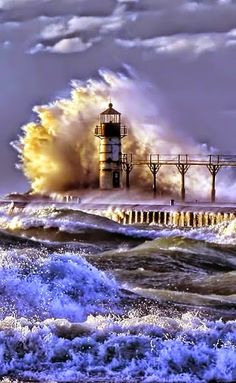 a lighthouse in the middle of an ocean with waves crashing over it