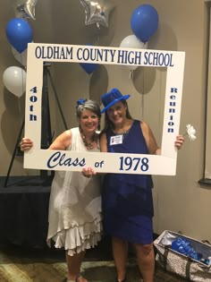 two women pose for a photo in front of a sign that reads class of'78