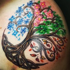 a tree with colorful leaves and flowers on it's back side shoulder tattoo design