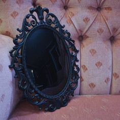 a mirror sitting on top of a pink couch