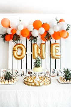 an orange and white dessert table with pineapples