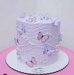 there is a white cake with pink butterflies on it