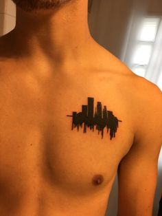 a man with a city skyline tattoo on his chest