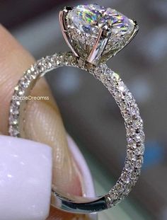 a close up view of a diamond ring on someone's finger