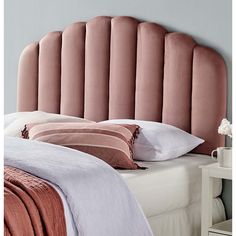 a pink headboard with pillows on top of it