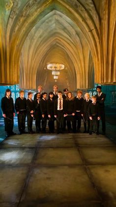 a group of young men standing next to each other in front of a cathedral ceiling