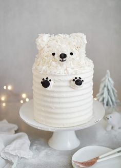 a cake with white frosting and black paw prints on the top is sitting on a plate