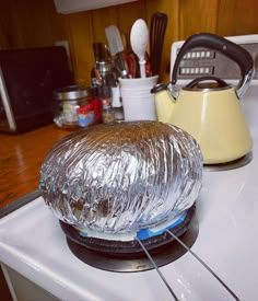 an image of food wrapped in foil on the stove top with cooking utensils