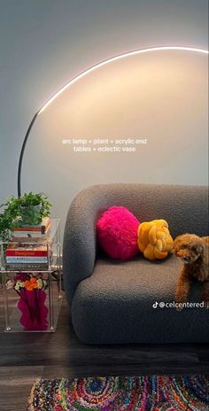 there is a couch with stuffed animals on it and a lamp in the corner next to it