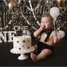 a baby sitting in front of a cake