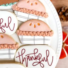 decorated cookies on a plate with the words happy thanksgiving written in red and white icing