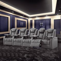 an empty movie theater with blue walls and black carpeted flooring, two recliners in front of the seats