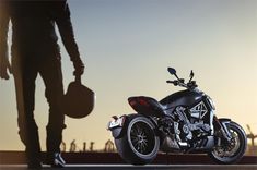 a person standing next to a parked motorcycle