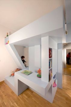 a room that has some kind of white shelf in the corner with books on it