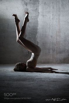 a woman in white leotards is doing a handstand on the floor