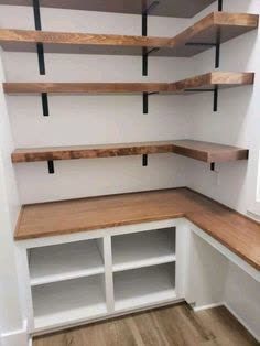 empty shelves in the corner of a room with wood flooring and white painted walls