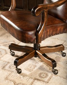 a brown leather office chair sitting on top of a rug