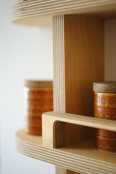 three wooden shelves with some jars on them