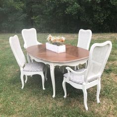 a white table and chairs in the grass