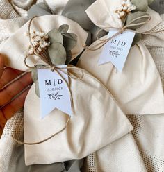 two small bags tied with twine on top of each other in front of a white cloth