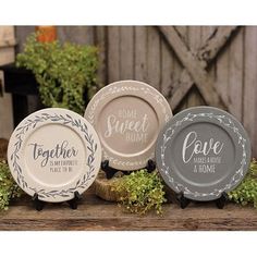 three plates sitting on top of a wooden table next to plants and potted plants