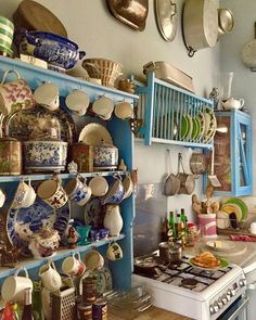 a kitchen filled with lots of pots and pans next to a stove top oven