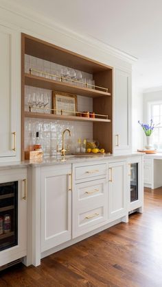 a kitchen with white cabinets and gold trim on the upper half of the cabinet doors