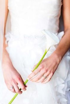 a woman in a wedding dress holding a flower