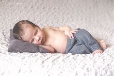 a baby sleeping on top of a blanket