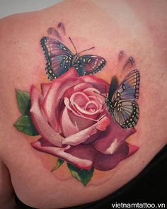 a woman's back with a rose and butterflies on it