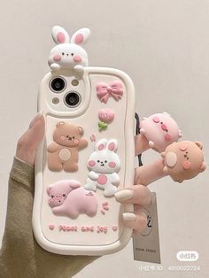 a person holding a cell phone case with various animal stickers on the back of it