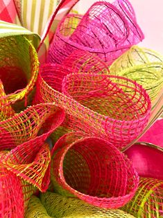 colorful baskets are stacked on top of each other with ribbons attached to the handles and sides