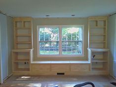 an empty room with bookshelves and windows