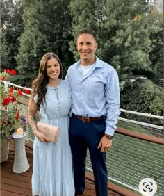 a man standing next to a woman on top of a wooden deck