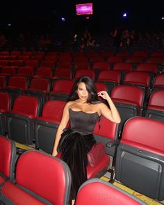 a woman sitting in an empty theater seat