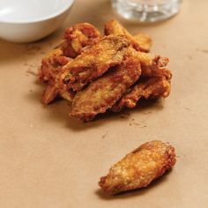 fried food sitting on top of a table next to a bowl