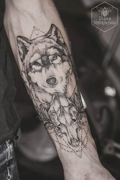 an arm with a wolf and flowers tattoo on the left side of the arm is shown