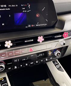 the interior of a car with an entertainment system and steering wheel controls, including flowers