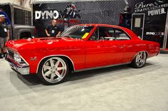 a red car is on display at an auto show