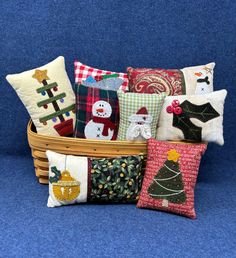 a basket filled with lots of pillows and christmas decorations on top of a blue surface