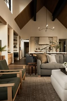 a living room filled with furniture next to a kitchen