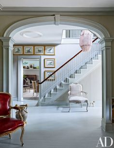 a living room filled with furniture next to a staircase