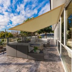 an outdoor living area with couches and tables