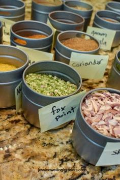 many different types of food in tins on a counter top with labels that read fix print