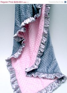 two blankets with ruffles on them sitting next to each other in front of a white wall