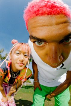 two people with pink hair posing for the camera