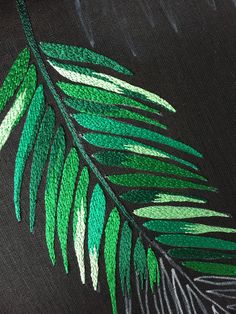 a close up of a green leaf on a black shirt