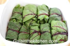 a white bowl filled with lettuce wrapped in red and green string wrappers