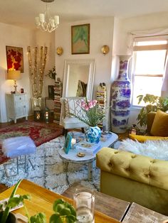 a living room filled with lots of furniture and flowers in vases on the table