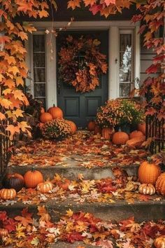 pumpkins and fall leaves are on the steps in front of a house